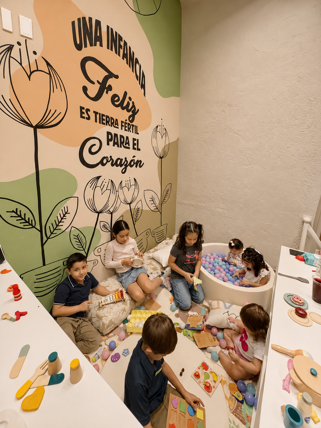 Ludoteca de Alere · niños jugando junto al mural y la alberca de pelotas
